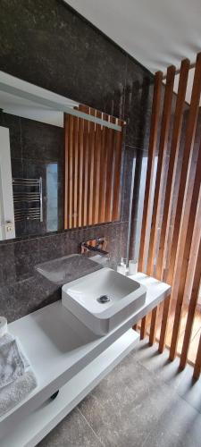 a bathroom with a white sink and a mirror at Villa Lina in Lourinhã