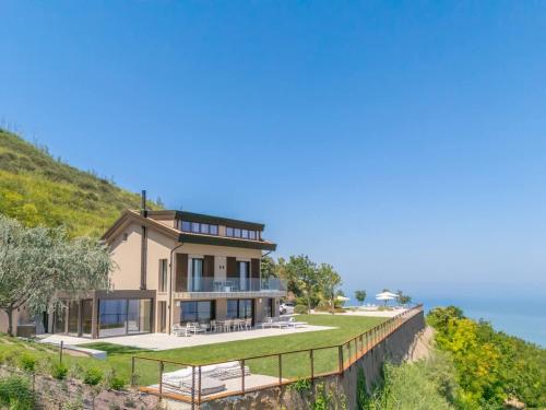 a house on a hill with a boardwalk at Terrazza Incanti - Piscina e Magia al Tramonto in Fiorenzuola di Focara