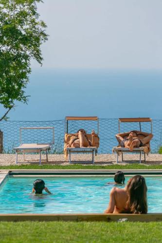 a group of people swimming in a swimming pool at Terrazza Incanti - Piscina e Magia al Tramonto in Fiorenzuola di Focara