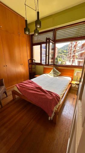 a bed in a room with a large window at Soul Etxia in Bermeo