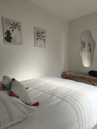 1 dormitorio con 1 cama blanca y paredes blancas en La Petite Escale, en Lunel