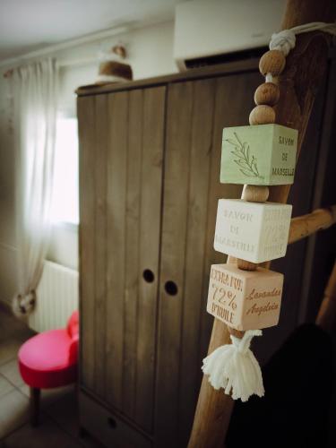 Un poste de madera con letreros en una habitación. en La Petite Escale, en Lunel