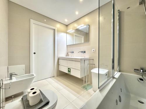 Faro Prestige by Homing في فارو: حمام مع حوض ومرحاض وحوض استحمام