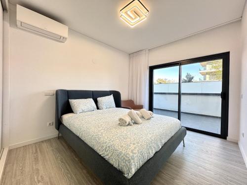 Faro Prestige by Homing في فارو: غرفة نوم بها سرير ونافذة كبيرة