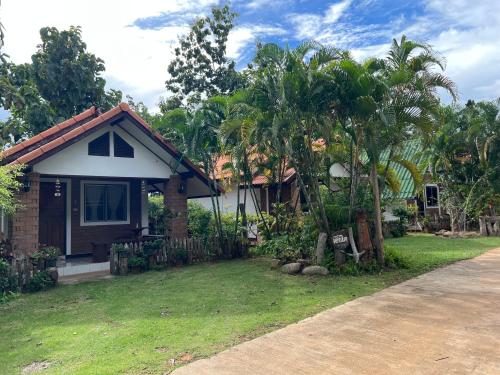 a small house with a yard with a tree at เฮินไตเกสเฮาส์ in Ban Nong Pa Ko