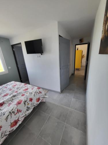 una camera da letto con un letto e una TV a schermo piatto di La maison de la Motte a La Motte-Fanjas