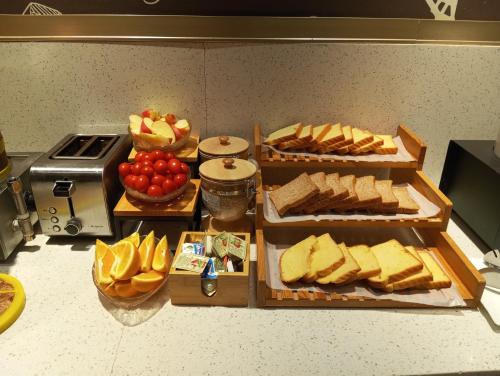 a table with three trays of bread and fruit at Hanting Hotel Shenzhen Luohu Port MixC in Shenzhen