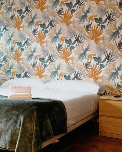 ein Schlafzimmer mit geblümter Tapete und einem Bett in der Unterkunft Hotel Ecolife Tenerife - Tenerife Sur in San Miguel de Abona
