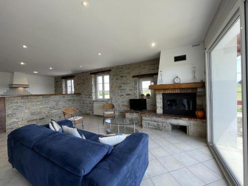 a living room with a blue couch and a fireplace at Loustaou in Bidache