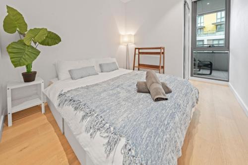 シドニーにあるCentral 2 Bedroom Condo Haymarketの青い毛布が掛けられたベッドのある寝室
