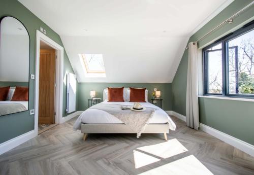 a bedroom with a bed and two windows at Barney's Barn in Woodbridge
