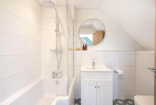 a white bathroom with a tub and a sink at Barney's Barn in Woodbridge