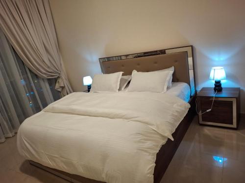 a bedroom with a large white bed with two lamps at luxury apartment 2 Bedroom and Big Hall in Ajman
