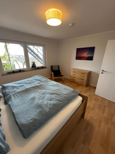 una camera da letto con un letto e una sedia di "An der alten Mühle 2" - Fewo 80qm, zentral gelegen, zwei Schlafzimmer, Südterrasse und Wallbox a Bad Bentheim