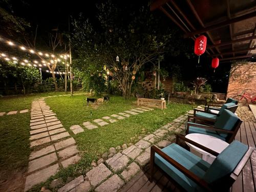 Eine Terrasse mit Stühlen und ein Hund im Garten bei Nacht in der Unterkunft Laoxao RiverStone Villa in Hoi An