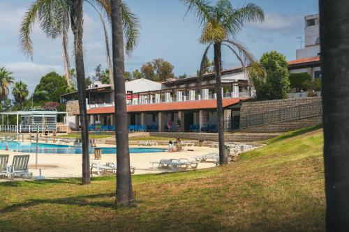 a resort with a swimming pool and palm trees at HolaCamp Albufeira in Albufeira