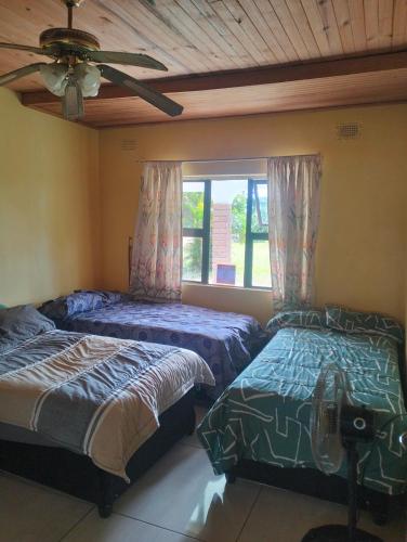 a bedroom with two beds and a window at Pro Rig in Sodwana Bay