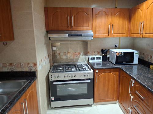 a kitchen with a stove and a microwave at luxury apartment 2 Bedroom and Big Hall in Ajman