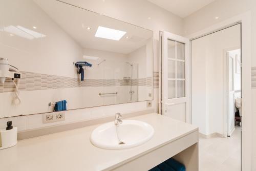 a white bathroom with a sink and a mirror at Apartment Old Town Reina Sofia 1 in Puerto del Carmen