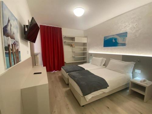 Un dormitorio con una cama y una cortina roja. en Hotel Angelini, en Nago-Torbole