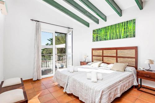 a white bedroom with a large bed and a window at Villa Casa Bonita by Villa Plus in Alaior