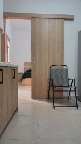 Una habitación con una silla y una puerta de madera. en Timbaki Theodosia T Brothers, en Tympáki