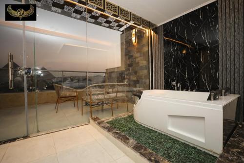 a bathroom with a white tub and a table and a balcony at Giza Inn Comfort view in Cairo