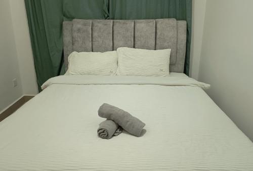 a towel laying on the end of a bed at Amber Cove - Luxury Design By Luxpro Management - 6~7 pax in Melaka