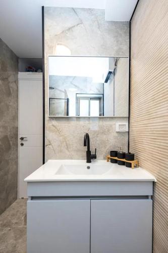 a bathroom with a white sink and a mirror at הפנינה של סוניה in Haifa