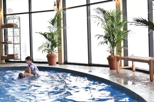 a little girl sitting in a hot tub in a building at Marritz Hotel in Perisher Valley