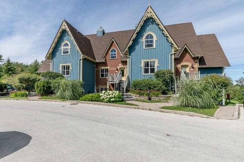 a blue house with a brown roof on a street at The Wine Barrel - Shuttle to Blue & Private Patio in Collingwood