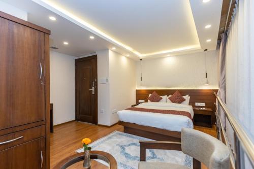 a hotel room with a bed and a table and a chair at Apex Business Hotel - Tribhuvan International Airport, Kathmandu in Kathmandu