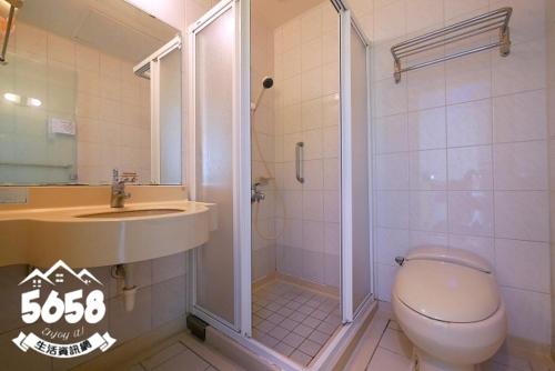 ein Badezimmer mit Dusche, Toilette und Waschbecken in der Unterkunft 85高雄港商旅 in Ta-lin-wei