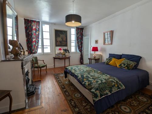 Châteauneuf-sur-CharenteChambre d'hôte AMELIE的一间卧室，里面有一张床，铺着蓝色被子。