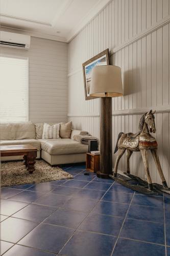a living room with a statue of a horse on the floor at The Little River Cottage - Riverfront Retreat in Murwillumbah