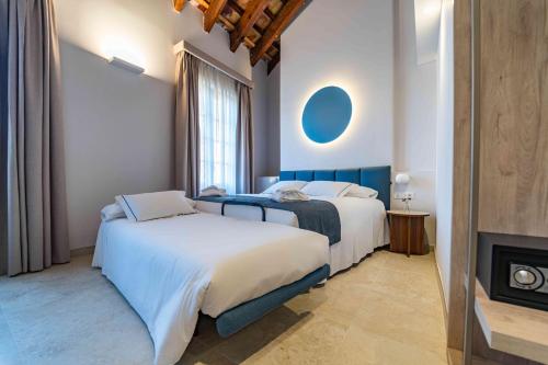 A bed or beds in a room at Hotel San Lorenzo Boutique Catedral
