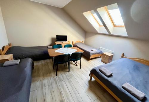 a room with two beds and a table and a window at MOSiR Reda in Reda