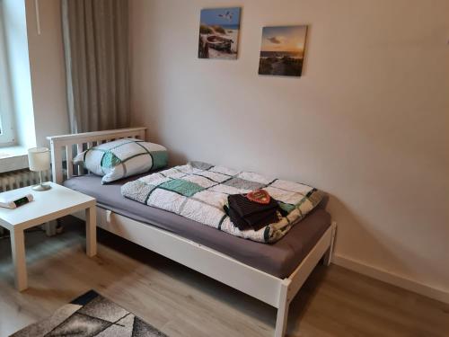 a small bed in a room with a table at Gemütliche Altbauwohnungen mit Einzelzimmern und Parkplatz direkt am Haus! in Bochum