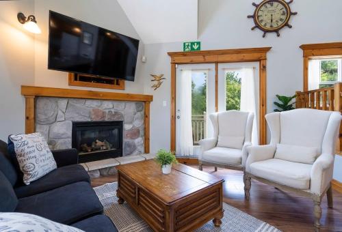 un soggiorno con tv e camino di Still Winds - Private Patio - Shuttle to Blue a Collingwood