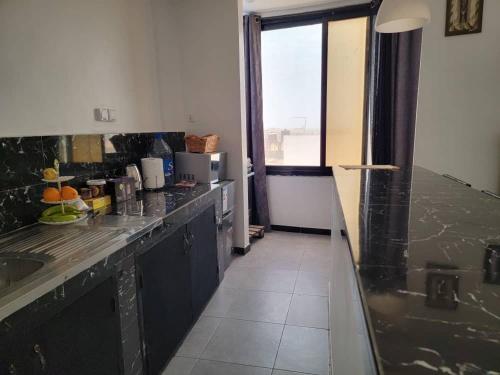 a kitchen with a black counter top in a room at Classimo in Dakar