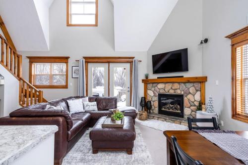 un soggiorno con divano e camino di Snowy Mountain Summit & Sol - Shuttle - Patio a Collingwood