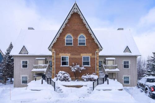una grande casa con la neve per terra di Snowy Mountain Summit & Sol - Shuttle - Patio a Collingwood