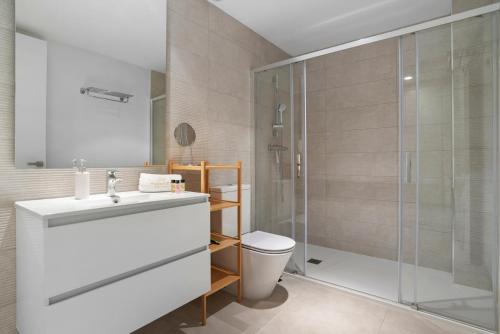 un bagno con doccia, lavandino e WC di Luxury 3BR Garden Apartment Estepona a Estepona