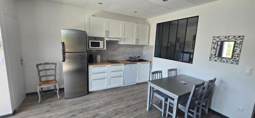 a kitchen with a refrigerator and a table with chairs at Ô Phil du Vent' in Ventabren