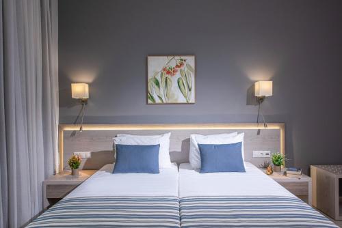 um quarto com uma cama grande com duas almofadas azuis em Saint George Gournes Bay em Goúrnai