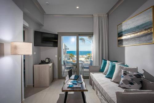 a living room with a couch and a view of the ocean at Saint George Gournes Bay "by Checkin" Adults Only in Gournes