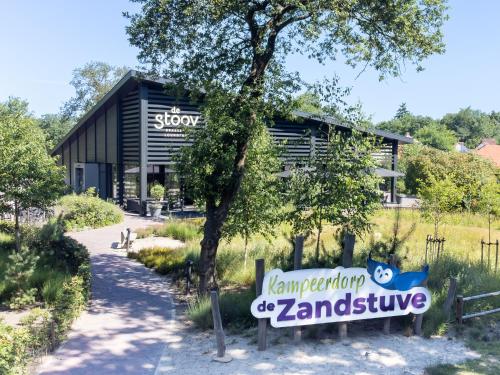 a building with a sign in front of it at Kampeerdorp de Zandstuve - Kindvriendelijke Vakantiepark in Rheeze