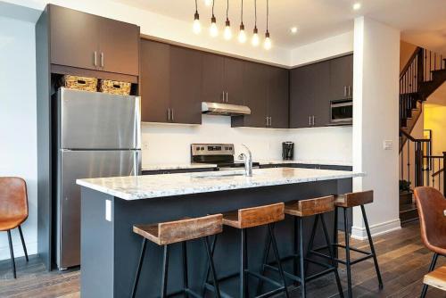eine Küche mit einer großen Theke und einem Kühlschrank in der Unterkunft Luxury Townhome - Private Patio Shuttle Trails in Collingwood