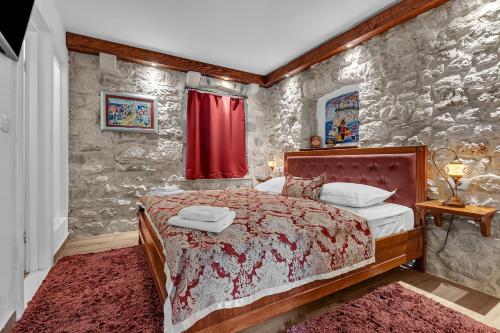 マカルスカにあるVilla Old Town Centre Makarska - Makarska Exklusivの石の壁の中にベッドが置かれた寝室