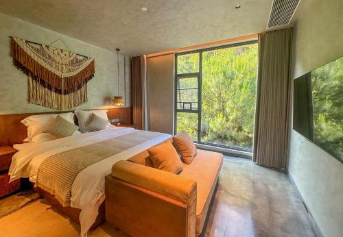 een slaapkamer met een groot bed en een groot raam bij LongSen Valley Inn in Zhukeng